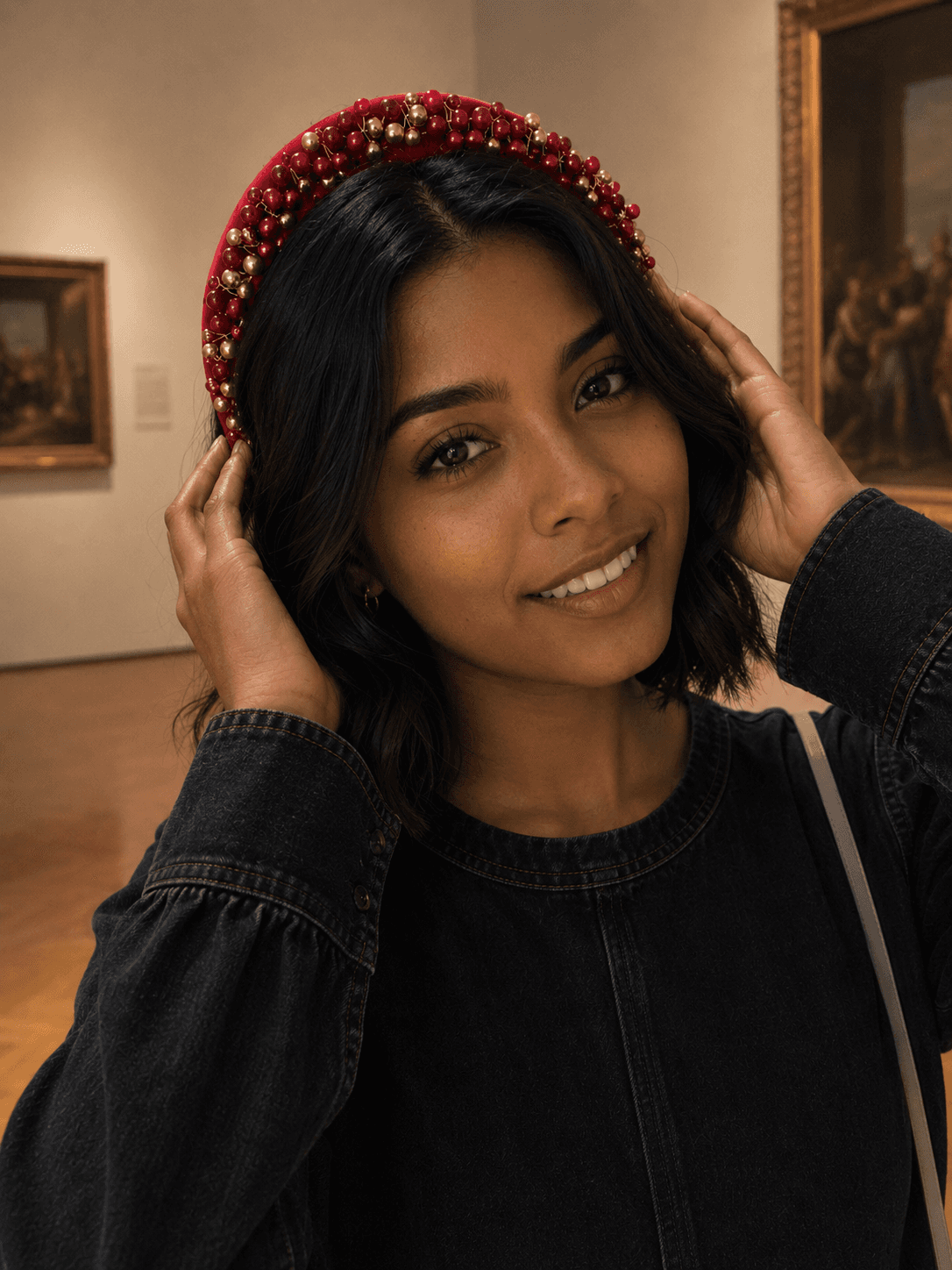 Clienta sonriente con diadema roja bordada con perlas doradas